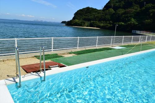 a swimming pool with a view of the water at Sea Tiger Island Inn Shodoshima in Shodoshima