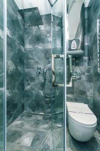 a bathroom with a toilet and a glass shower at Luxury Apartments Arena Guliver in Kyiv