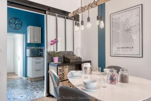 a dining room with a white table and chairs at The Clock House, 3 étoiles in La Rochelle