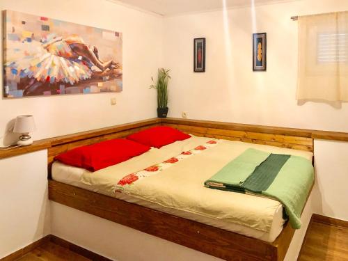 a bed in a room with a painting on the wall at Apartments Mokalo in Orebić