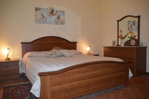 a bedroom with a bed and two dressers and a mirror at Nido d'Aquila in Collodi