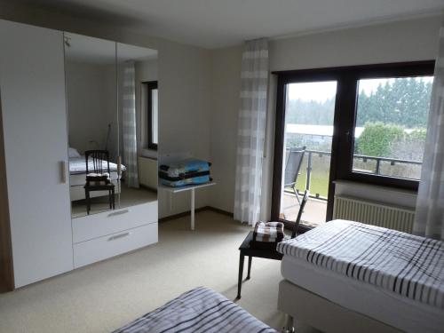 a bedroom with a bed and a mirror and a window at Ferienwohnung WällerAuszeit in Bach