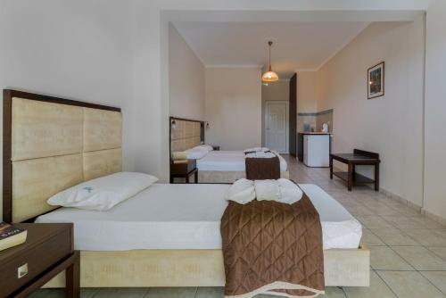 Habitación de hotel con 2 camas y cocina en Hotel Cronulla en Kalamaki