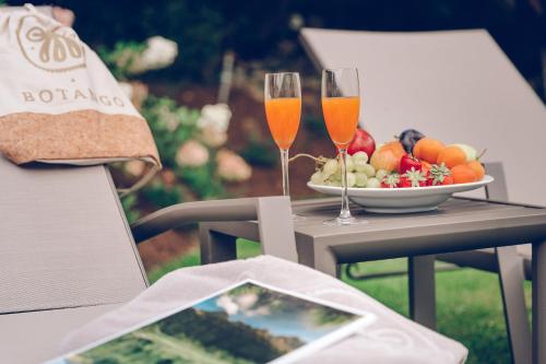 a table with two glasses of wine and a bowl of fruit at Botango in Parcines