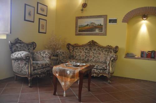 a living room with two chairs and a table at Nido d'Aquila in Collodi