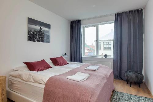 a bedroom with a large bed and a window at Tyr Apartments by Heimaleiga in Reykjavík