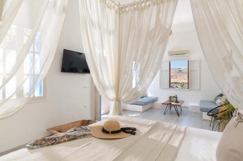 a hat sitting on a bed in a bedroom at Lindos Beach Boutique Villa in Lindos