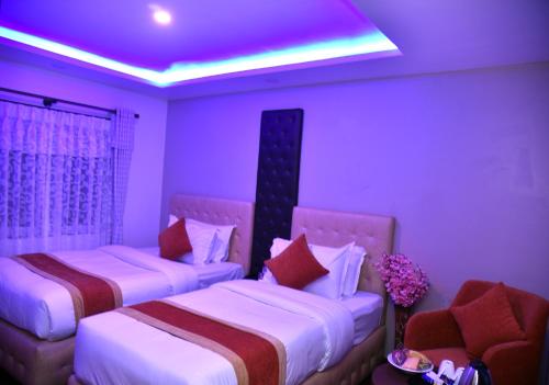 two beds in a room with a purple ceiling at Marinha Airport Hotel in Kathmandu