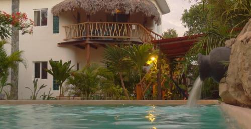 a house with a balcony and a swimming pool at Zamunda Garden View in Tulum