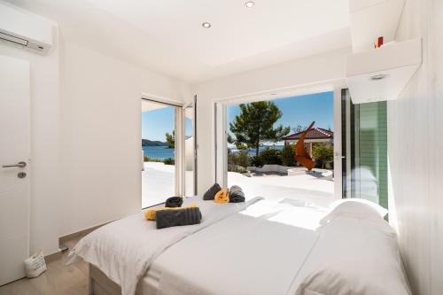 ein Schlafzimmer mit einem weißen Bett und einem großen Fenster in der Unterkunft Villa Soleil in Vela Luka