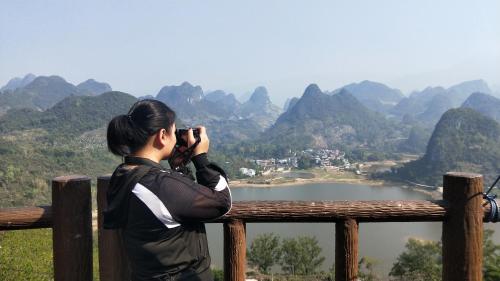 a person taking a picture of a mountain view at Secret Courtyard Resort Hotel in Guilin