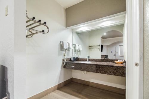 ein Bad mit einem Waschbecken und einem Spiegel in der Unterkunft Scottish Inn and Suites Baytown in Baytown