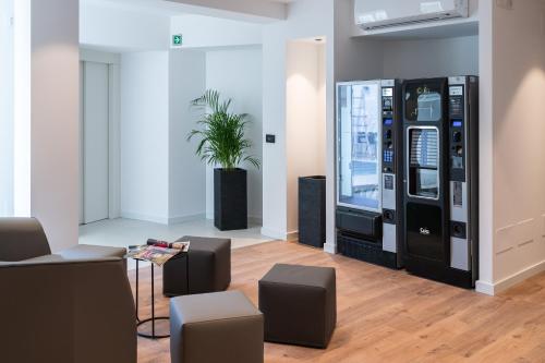 a room with a vending machine and some chairs at Comfort Zone in Codroipo