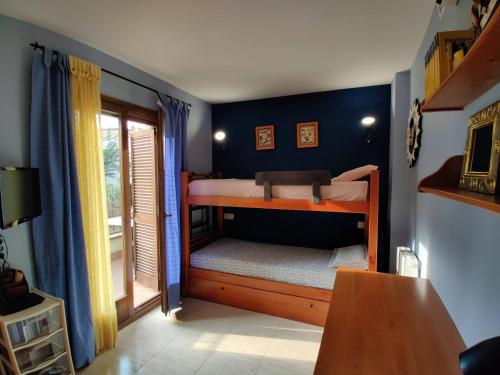トッサ・デ・マールにあるHoliday Tossa Apartmentの二段ベッド2台とテーブルが備わる客室です。