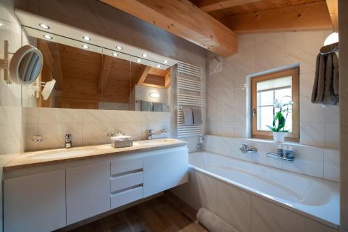 baño con bañera grande y lavamanos en Exklusive Dachwohnung mit herrlicher Aussicht, en Klosters
