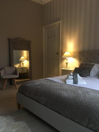a bedroom with a large bed and a mirror at La MeusÂme in Dinant