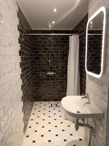 a black and white bathroom with a sink and a shower at Tokeryds Herrgård in Jönköping