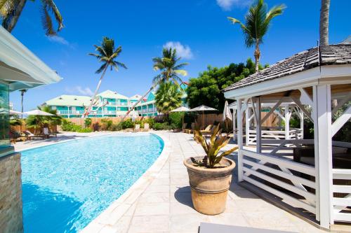 una piscina en un complejo con cenador y palmeras en Résidence La Plage Orient Bay by La Conciergerie FWI, en Saint Martin