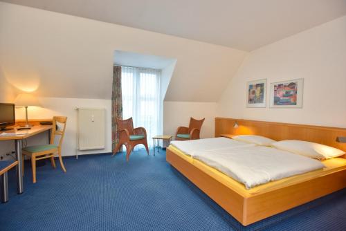 ザルシュテットにあるHotel Fasanengartenのベッドとデスクが備わるホテルルームです。