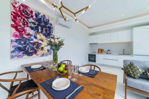 a dining room with a wooden table and chairs at MIREVA Villas in Haad Pleayleam