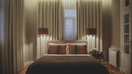 a bedroom with a bed with two pillows and a window at Casal dos Capelinhos - Douro in Santa Marta de Penaguião
