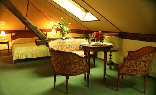 a bedroom with a bed and a table and chairs at Pensjonat Pałacyk in Łańcut