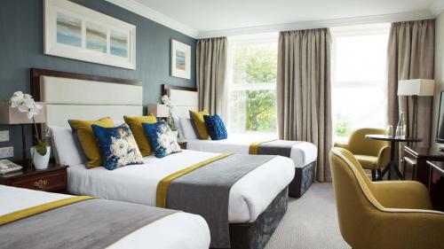 a hotel room with two beds and a desk at Anner Hotel in Thurles