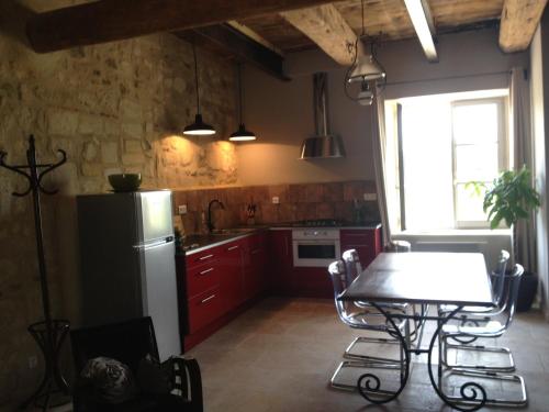 eine Küche mit einem Kühlschrank und einem Tisch mit Stühlen in der Unterkunft Le Mas de Lucas in Arles