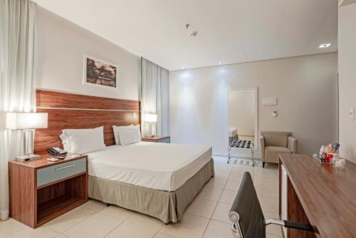 a hotel room with a bed and a desk at Slaviero Porto Velho in Porto Velho