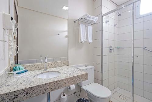 a bathroom with a toilet and a sink and a shower at Slaviero Porto Velho in Porto Velho