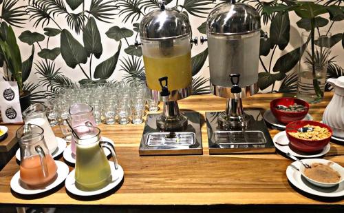a wooden table with two coffee makers and drinks at O2 Hotel Iguazu in Puerto Iguazú