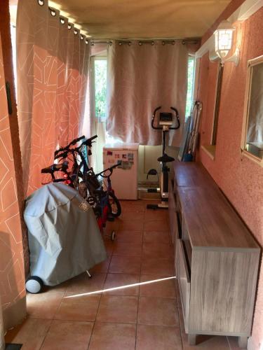 a room with two bikes parked in a room at CAVALAIRE vue MER au loin MAISONNETTE TOUT ÉQUIPÉE POUR 4 PERSONNES AVEC PISCINE CLIM WIFI VÉLOS TV BARBECUES in Cavalaire-sur-Mer