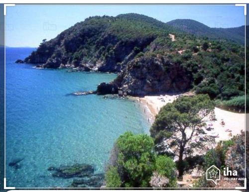 a view of a beach with trees and blue water at CAVALAIRE vue MER au loin MAISONNETTE TOUT ÉQUIPÉE POUR 4 PERSONNES AVEC PISCINE CLIM WIFI VÉLOS TV BARBECUES in Cavalaire-sur-Mer