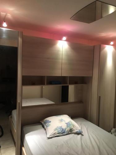 a bedroom with two bunk beds with a pillow at CAVALAIRE vue MER au loin MAISONNETTE TOUT ÉQUIPÉE POUR 4 PERSONNES AVEC PISCINE CLIM WIFI VÉLOS TV BARBECUES in Cavalaire-sur-Mer