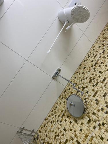 a bathroom with a mirror on a tile floor at Rossi Hotel in Comodoro