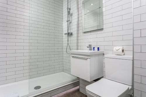 Cairn Suite - Donnini Apartments في آير: حمام ابيض مع مرحاض ومغسلة