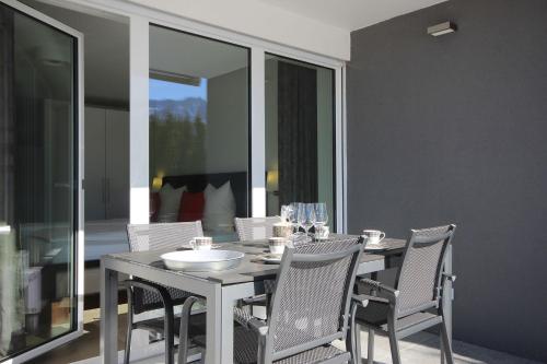 a dining table and chairs in a room with glass windows at Appartement Falkenstein in Nesselwang