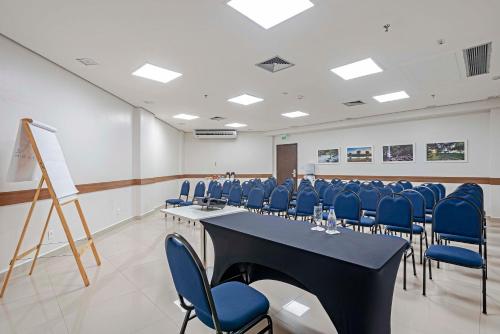a conference room with a long table and blue chairs at Slaviero Porto Velho in Porto Velho