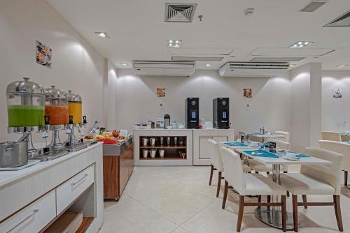 a large kitchen with a table and chairs in it at Slaviero Porto Velho in Porto Velho