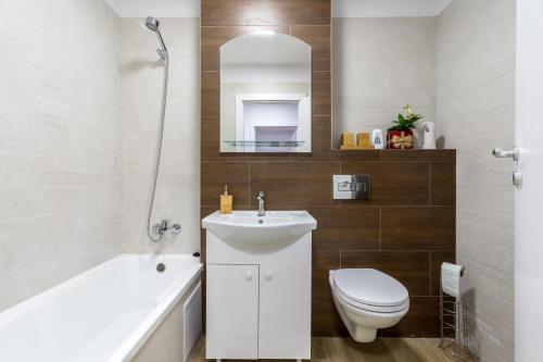 een badkamer met een wastafel, een toilet en een bad bij Apartament LYAD in Sighişoara
