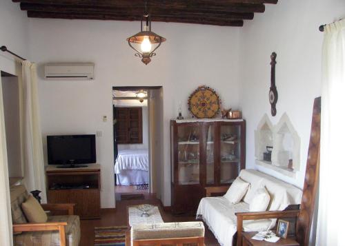 a living room with a couch and a tv at Elpida's Stone Houses in Goudhi