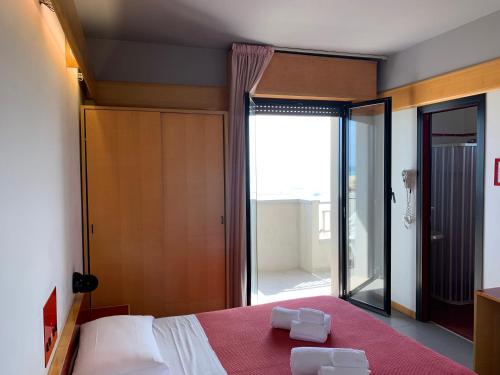 a bedroom with a bed with two white towels on it at Hotel Giglio in Rimini