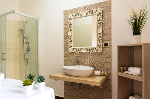 a bathroom with a sink and a mirror on a wall at Lillà - Home and Garden in Riposto