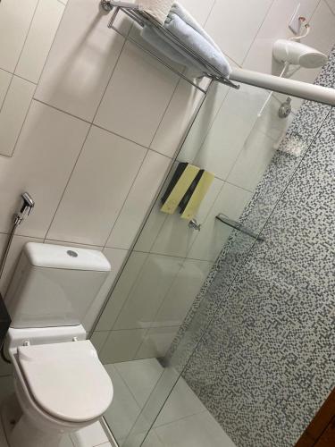 a bathroom with a toilet and a glass shower door at Rossi Hotel in Comodoro