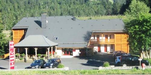a large building with cars parked in a parking lot at RÉSID BEC DE L AIGLE Studio 21 - LE LIORAN in Laveissière