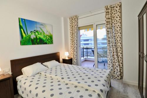1 dormitorio con cama y vistas a un balcón en Apartment Bellisimo, en Lloret de Mar