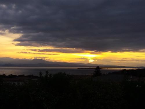 a sunset over a body of water with the sun setting at Barcuzzi in Barcuzzi