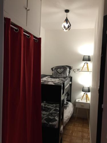 mały pokój z łóżkiem i czerwoną zasłoną w obiekcie Appartement Orelle - Val Thorens w mieście Orelle
