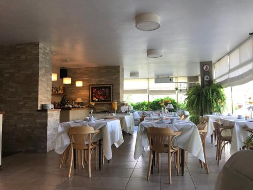 a restaurant with tables and chairs with white table cloth at Hotel Europa in Ostende