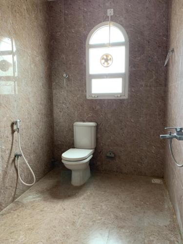 uma casa de banho com um WC e uma janela em Al Shraija Castle , Al Jabal Al Akhdar em Al ‘Aqar